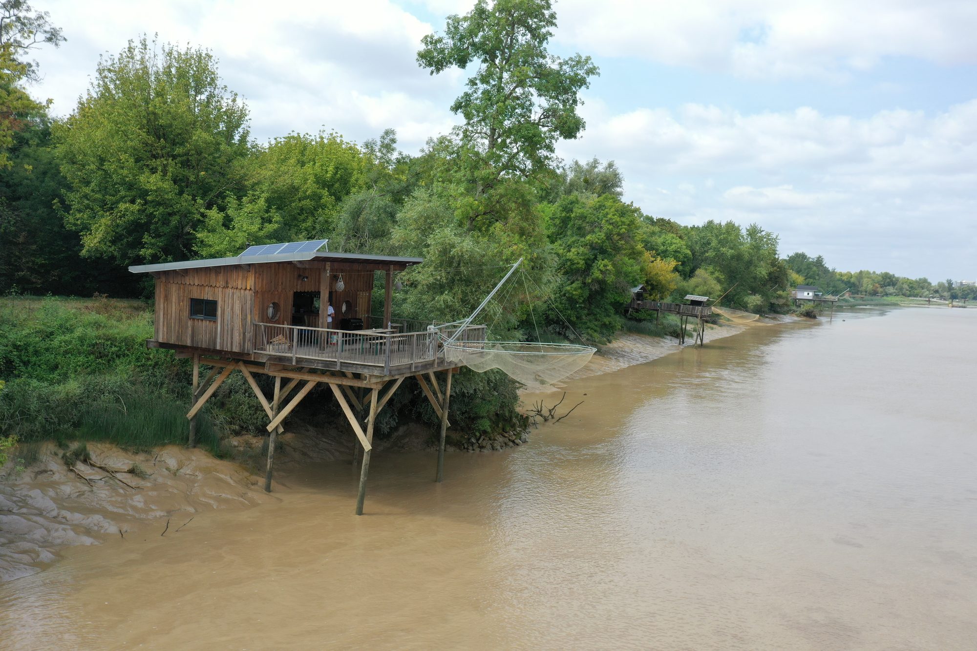 Le carrelet sur pilotis, filet descendu dans l'eau, sur la rive de l'estuaire de la Gironde