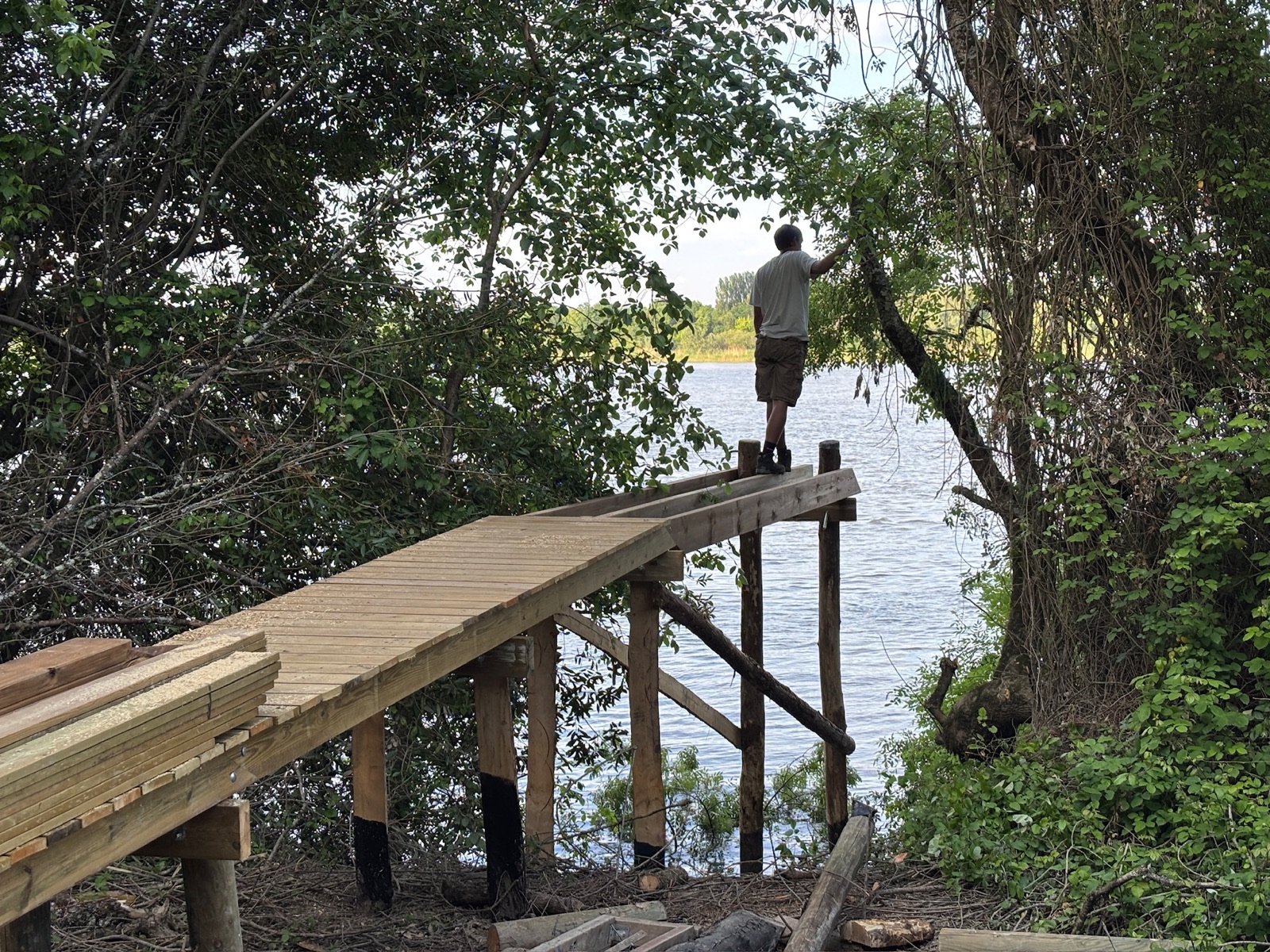 Passerelle d'accès au carrelet au-dessus de l'eau, plancher bois patiné, garde-corps simples